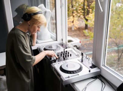 Musician wearing headphones using dj console