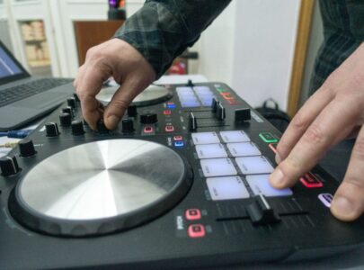 Hands working on a dj console in a room
