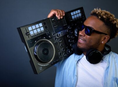 Cool guy with dark glasses on shoulder holds DJ console