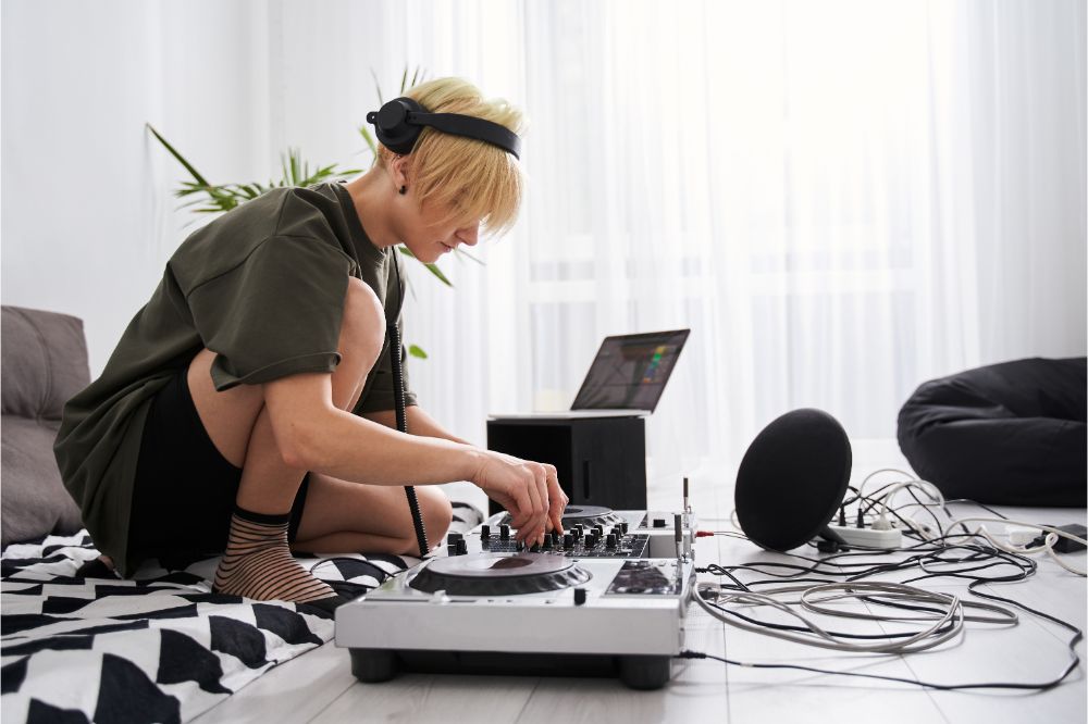 Female musician wearing headphones using dj console