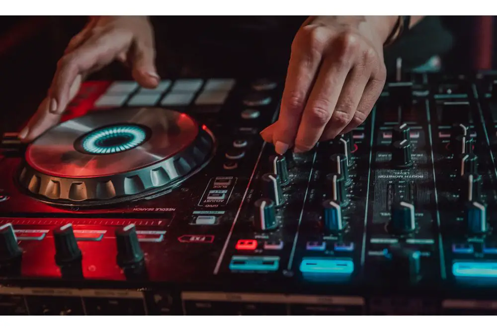 DJ Hands creating and regulating music on dj console mixer in concert nightclub stage