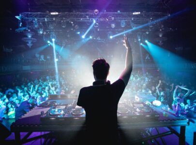 Silhouette of DJ in nightclub with hands up